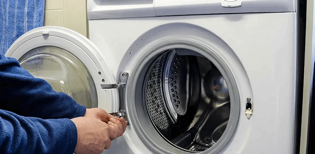 Washing machine repair handyman checking a front-load washer door and latch in Tempe, AZ